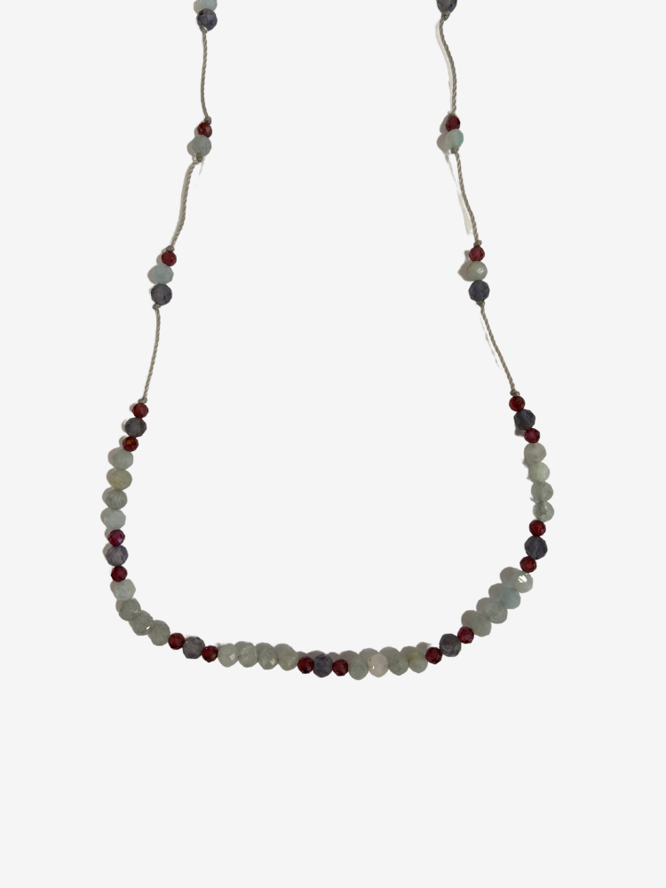 Collier line rakhi me composé de différentes pierres: calcédoine, iolite et zircon violet sur des fils de couleurs gris perle.