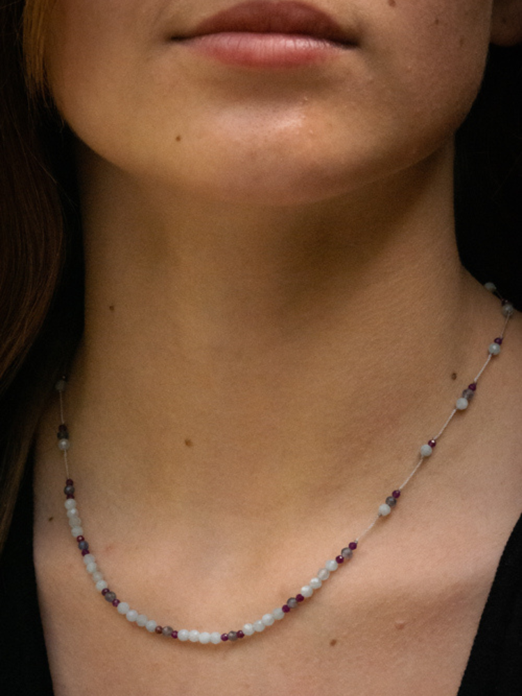 Collier line rakhi me composé de différentes pierres: calcédoine, iolite et zircon violet sur des fils de couleurs gris perle.